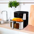 TESLA AirCook Q60 XXL Pro multifunktionsfritteuse auf der küchenarbeitsplatte, die eine portion pommes frites und zwiebelringe zubereitet.